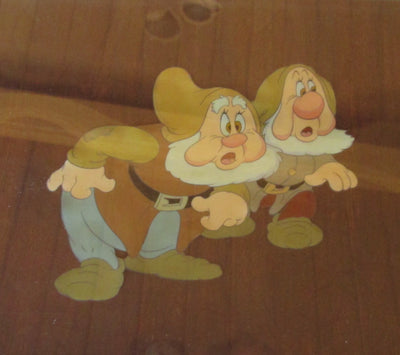 Original Walt Disney Production Cel on Custom Woodgrain Background from Snow White and the Seven Dwarfs featuring Happy and Sneezy